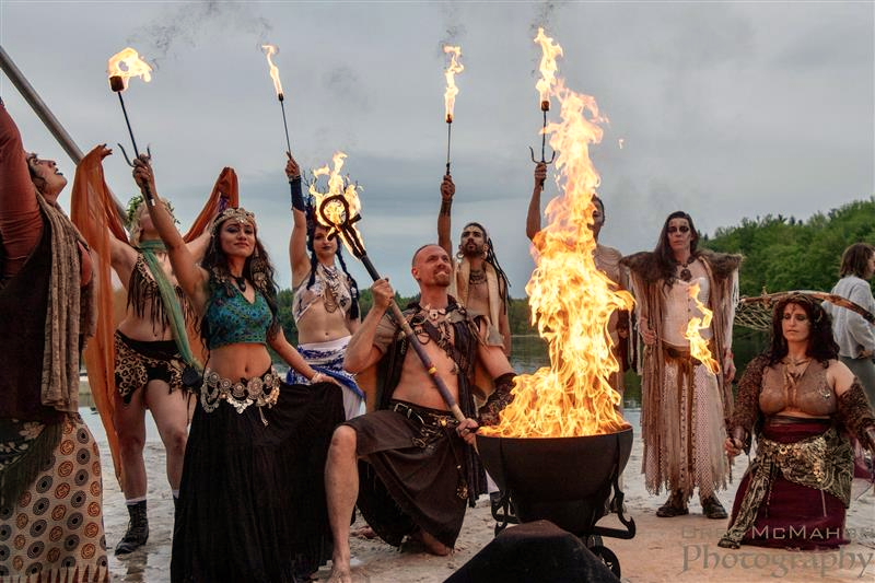 An outdoor celebration surrounding a theatrical fire moment